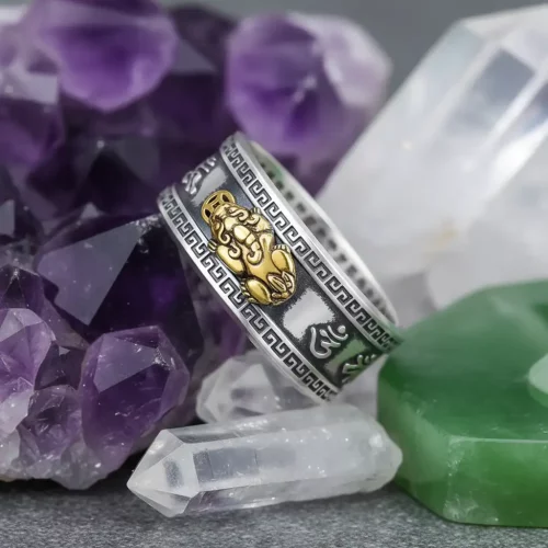 Silver Pixiu mantra ring displayed with amethyst crystals and jade for feng shui energy