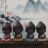 Set of four small Buddha statues in meditation pose displayed against traditional Chinese ink wash painting featuring lotus flowers and misty mountains