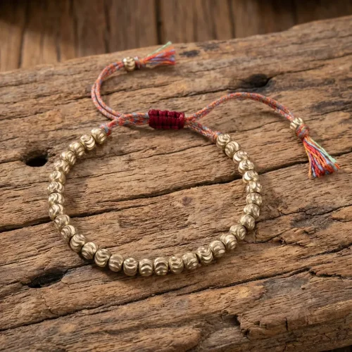 Handcrafted tibetan brass bead bracelet on rustic wood buddhist mala wrist band