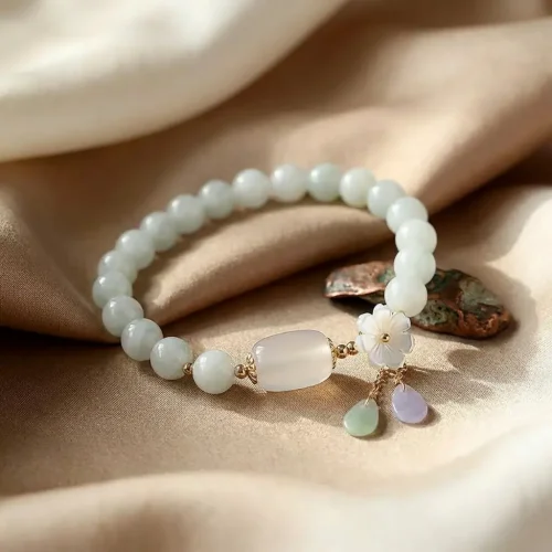 Jade flower bracelet on silk fabric background