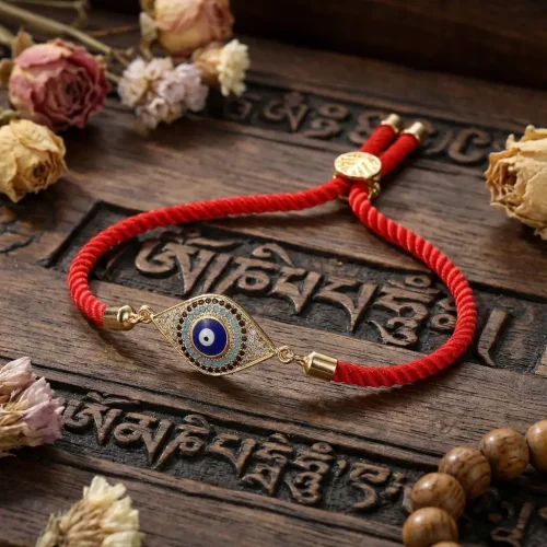 Red string evil eye bracelet on carved tibetan mantra prayer board