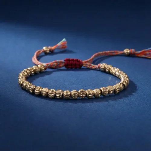 Tibetan brass prayer bracelet gold copper beads on navy blue background