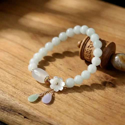 White jade flower charm bracelet on wood background