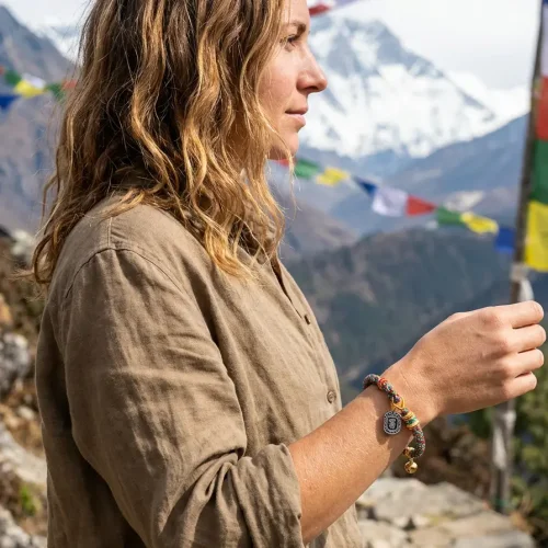 Woman wearing tibetan prayer bracelet in himalayan mountain landscape