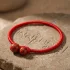 Tibetan red string bracelet on mantra stone