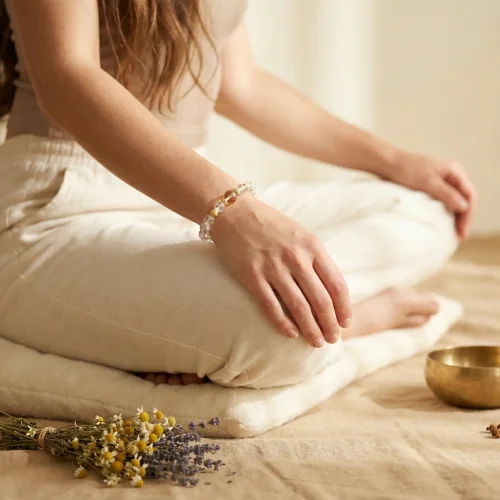 Woman wearing clear quartz bracelet during meditation