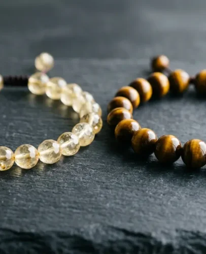 Citrine vs Tiger Eye Bracelet Comparison Side-by-side comparison of a yellow citrine bracelet and a golden tiger eye bracelet on a dark stone surface