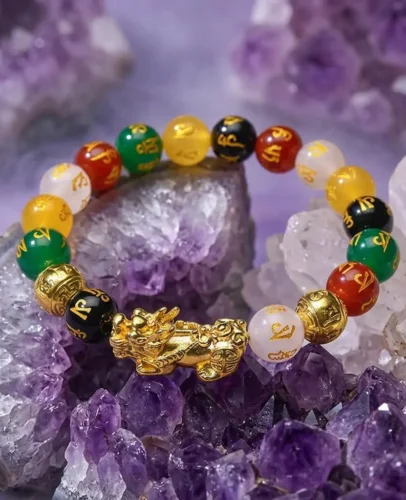 pixiu-five-elements-agate-bracelet-amethyst-crystal-potalastore Gold-plated Pixiu five elements agate bracelet with red, green, yellow, white, and black beads resting on raw amethyst crystal cluster