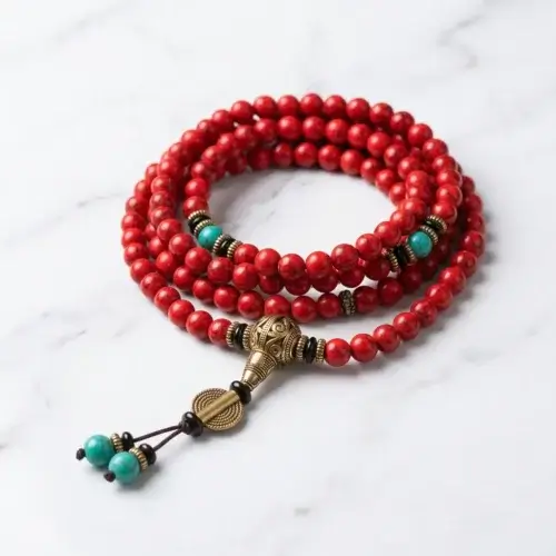 Tibetan mala red turquoise 108 beads necklace with antique brass guru bead on white marble background