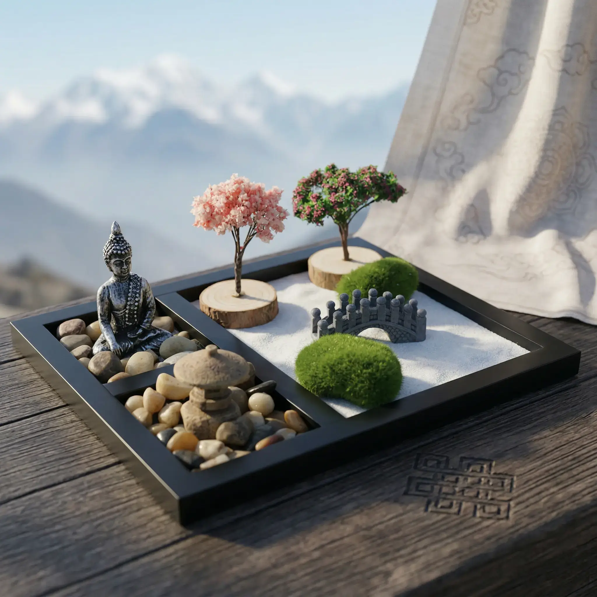 Meditation Zen Garden Desk Decor with Buddha Statue and Himalayan Mountain View – PotalaStore Buddha zen garden kit for desk on a dark wooden surface with a Tibetan cloud-pattern fabric and snow-capped Himalayan mountains in the background, featuring meditating Buddha statue, cherry blossom tree, flowering tree on wood-slice bases, stone arch bridge, two moss balls, and white sand — PotalaStore