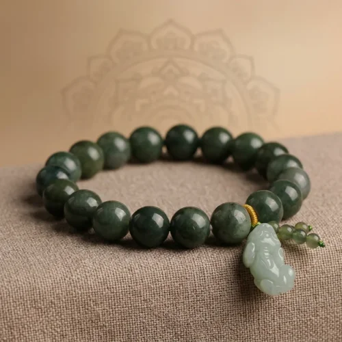 Feng Shui green jade Pixiu wealth bracelet resting on a beige textured fabric with a faint spiritual mandala design in the background