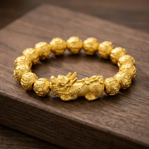 Gold Pixiu feng shui wealth bracelet with Om Mani Padme Hum engraved 12mm beads, displayed on dark walnut wood surface – PotalaStore