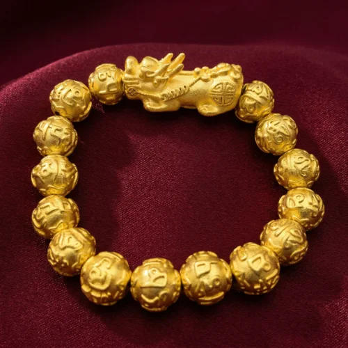 Gold Pixiu Pi Xiu wealth mantra bracelet on deep red Tibetan silk fabric, highlighting sacred bead engravings and celestial Pixiu charm