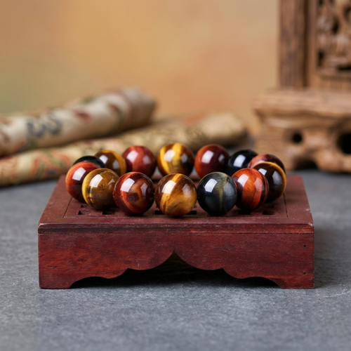 Genuine 10mm tri-color tiger's eye bracelet featuring golden, red and blue beads, resting on a traditional Tibetan rosewood stand with prayer scroll and carved wood in the background