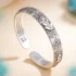 Close-up of Fortune Pixiu Lucky Bangle showing the Heart Sutra engraved on the inner band and the 足银999 fine silver hallmark stamp, with turquoise stones in background