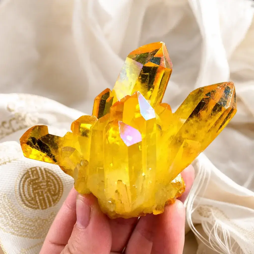 natural-citrine-crystal-cluster-prosperity-stone Hand holding a natural citrine crystal cluster over white silk with Chinese auspicious emblem — monk-blessed prosperity stone from PotalaStore for wealth and abundance