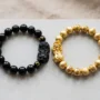Black obsidian Pixiu bracelet and gold Pixiu bracelet displayed side by side for comparison