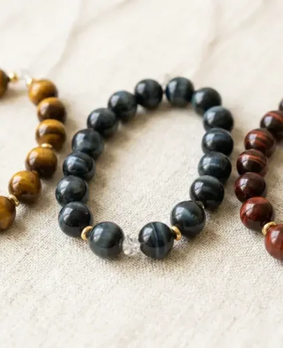 Blue Red and Gold Tiger Eye Bracelets Compared Three tiger eye bracelets side by side in gold, blue, and red showing chatoyancy bands