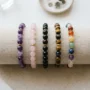 Crystal bracelets arranged by intention A row of beaded crystal bracelets in amethyst, rose quartz, black obsidian and tiger's eye on linen