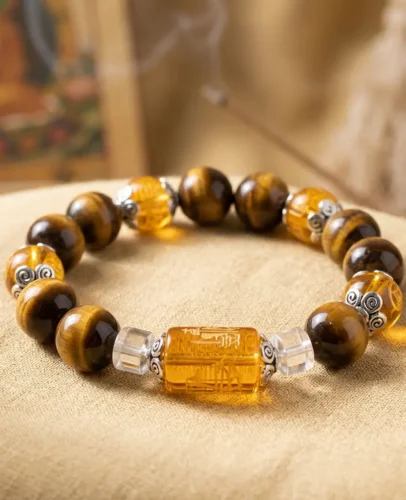 Tiger eye fortune lucky bracelet with engraved mantra bead and silver spiral spacers, displayed beside a thangka and incense.
