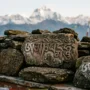 Om Mani Padme Hum Mantra Carved in Tibetan Script Om Mani Padme Hum mantra carved in Tibetan script on weathered mani stones in the Himalayas