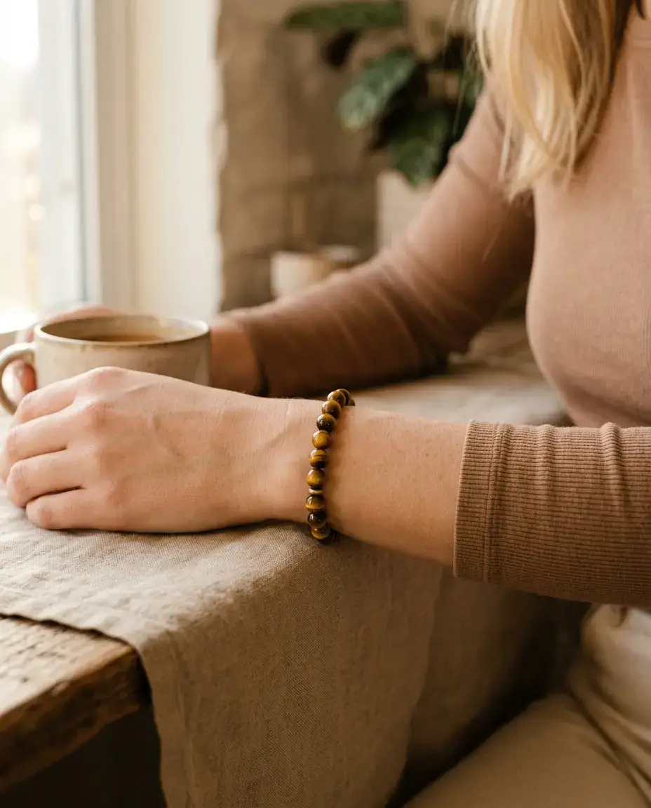 Golden tiger eye bracelet on a wrist near the solar plexus illustrating confidence and grounding energy