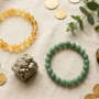 best-crystals-for-money-and-wealth-hero flat lay of best crystals for money and wealth including citrine, pyrite and green aventurine bracelets