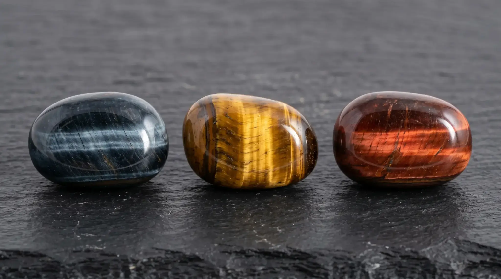 Blue, gold, and red tiger eye stones side by side showing iron oxidation color differences