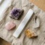 crystal-mistakes-beginners-hero.jpg Beginner crystal collection with amethyst, rose quartz, and selenite on a wooden tray showing common crystal care mistakes