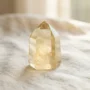 natural-citrine-crystal-merchants-stone Natural golden-yellow citrine crystal point known as the Merchant's Stone, on a warm neutral background