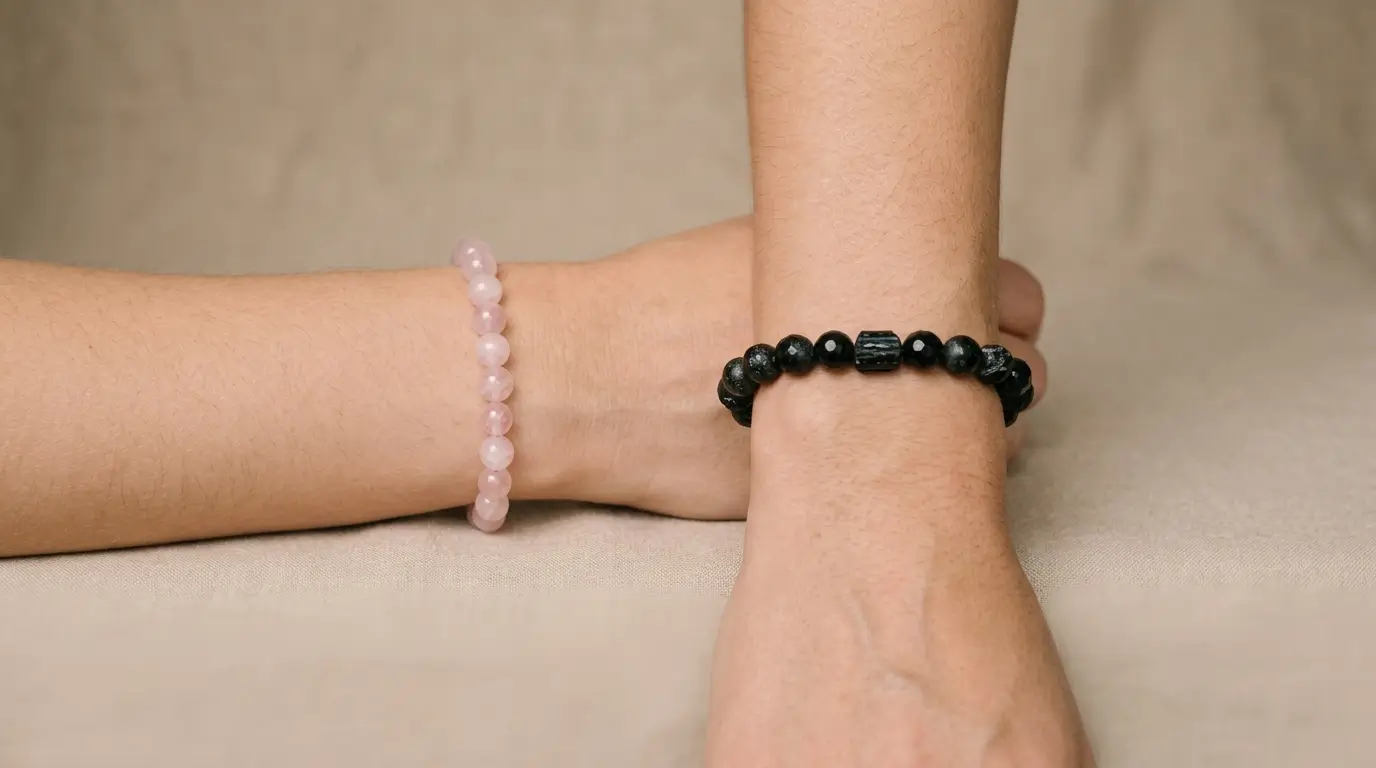 Two wrists shown side by side wearing crystal bracelets, illustrating left wrist to draw energy in and right wrist to project energy out