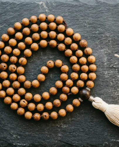 108-sandalwood-mala-beads-guru-bead-tassel Flat lay of meaningful crystal and mala bead gifts for Christmas 2026, including rose quartz, amethyst, and a sandalwood mala
