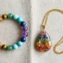 Chakra Bracelet vs Chakra Necklace Comparison Seven-stone chakra bracelet and rainbow chakra pendant necklace displayed side by side on light linen