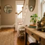 laughing-buddha-entryway-placement Brass Laughing Buddha statue on a 30-inch console table, placed diagonally across from a home's front entrance and facing into the room