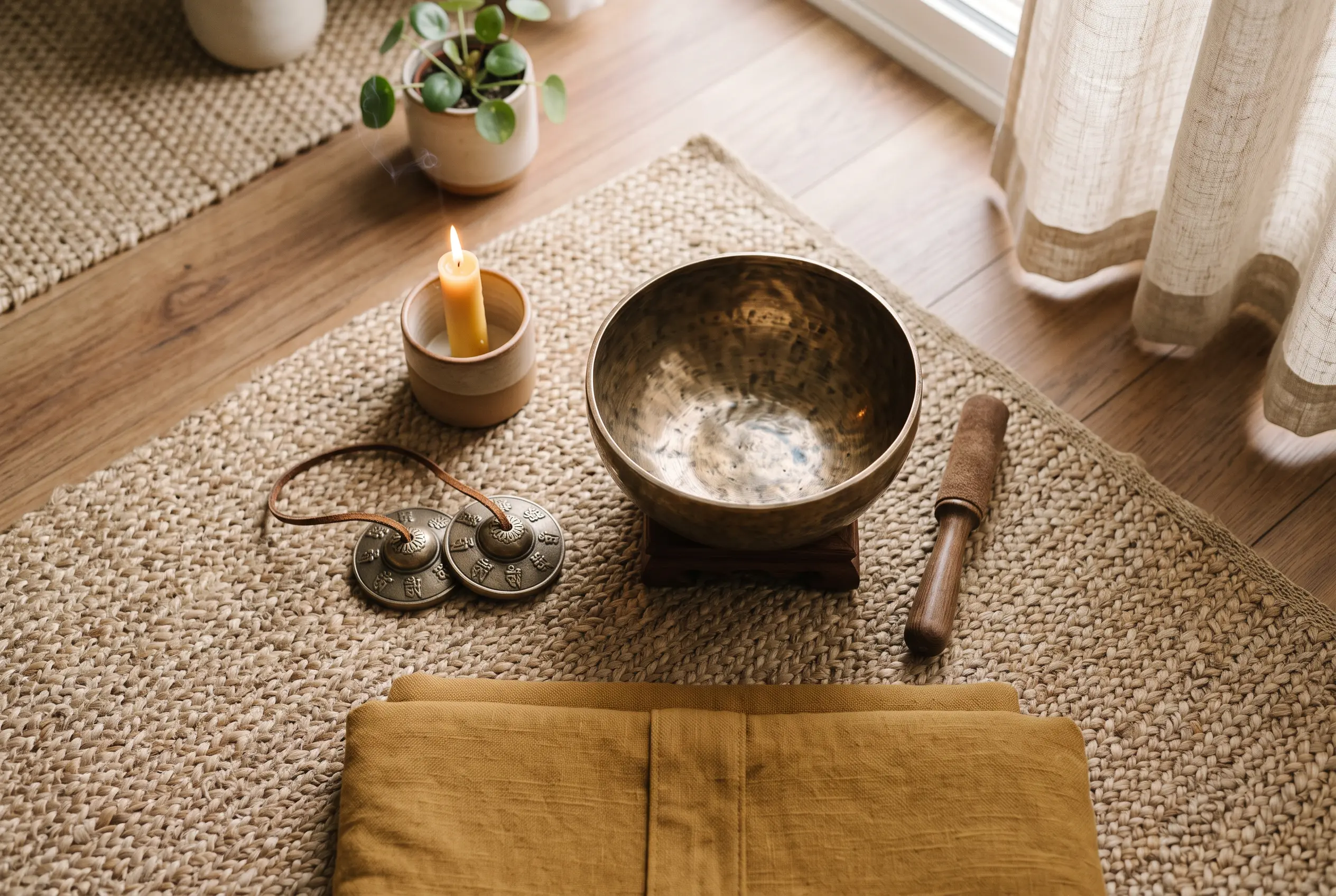 Sound bath setup with tingsha cymbals and a singing bowl arranged for a meditation session