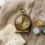 111-angel-number-clock-manifestation-crystals Clock showing 1:11 beside clear quartz, citrine and moonstone crystals on warm linen, illustrating the 111 angel number