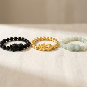 Gelang obsidian hitam, emas dan pixiu jed bersebelahan menunjukkan tiga pilihan bahan pixiu utama