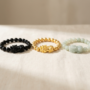 Black Obsidian, Gold, and Jade Pixiu Bracelets Compared Black obsidian, gold, and jade pixiu bracelets side by side showing the three main pixiu material choices