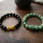 black-obsidian-pixiu-vs-jade-pixiu-side-by-side Black obsidian Pixiu bracelet and green jade Pixiu bracelet placed side by side for comparison