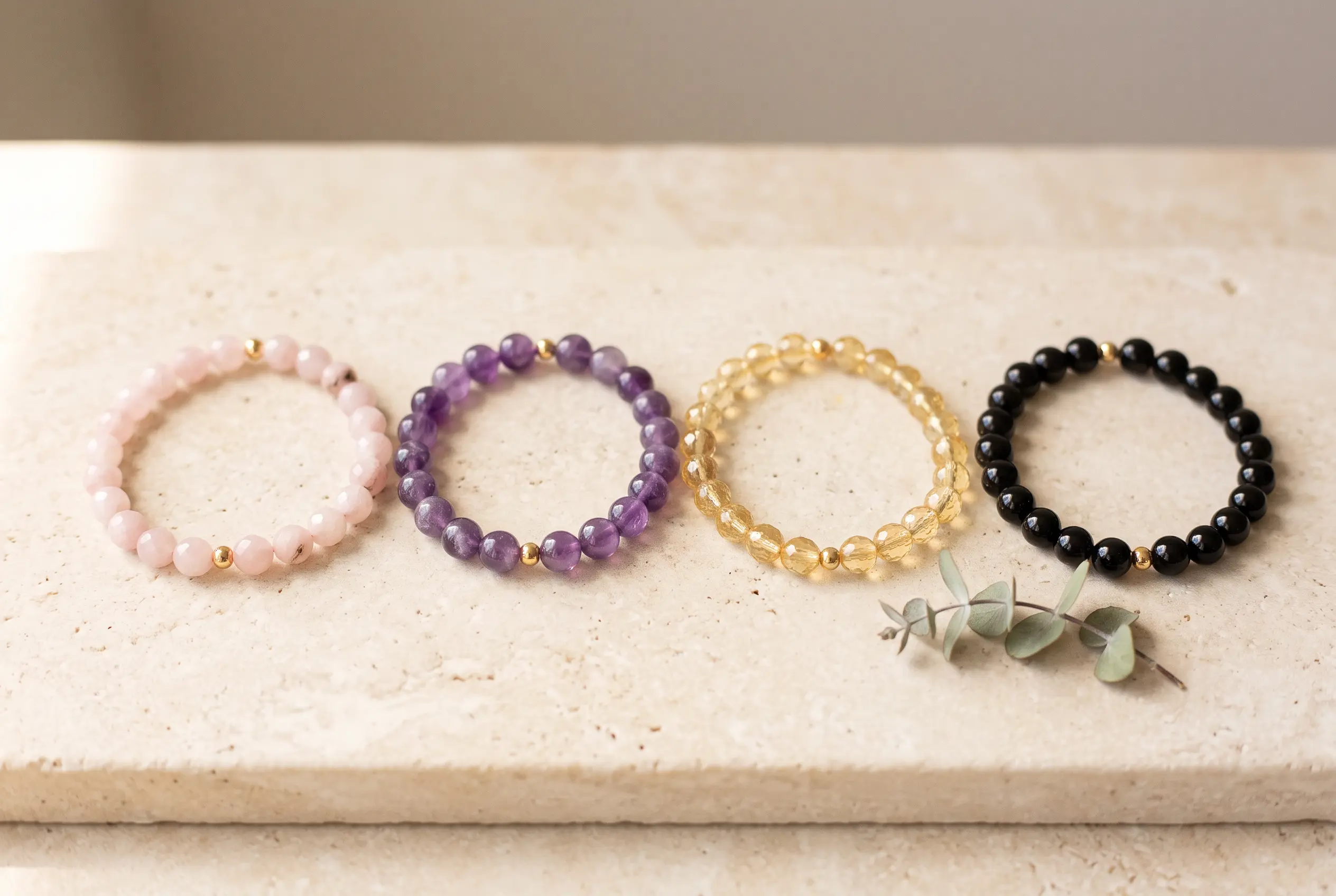 Rose quartz, amethyst, citrine, and black obsidian bracelets laid out for a mindful Christmas gift guide