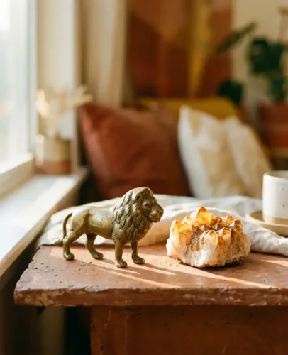 Golden lion figurine beside a glowing citrine crystal cluster in warm sunset light, symbolizing Leo season 2026