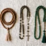 En mala, en katolsk rosenkrans og en islamisk tasbih arrangeret side om side, hvilket viser, hvordan de tre bedepærer adskiller sig.