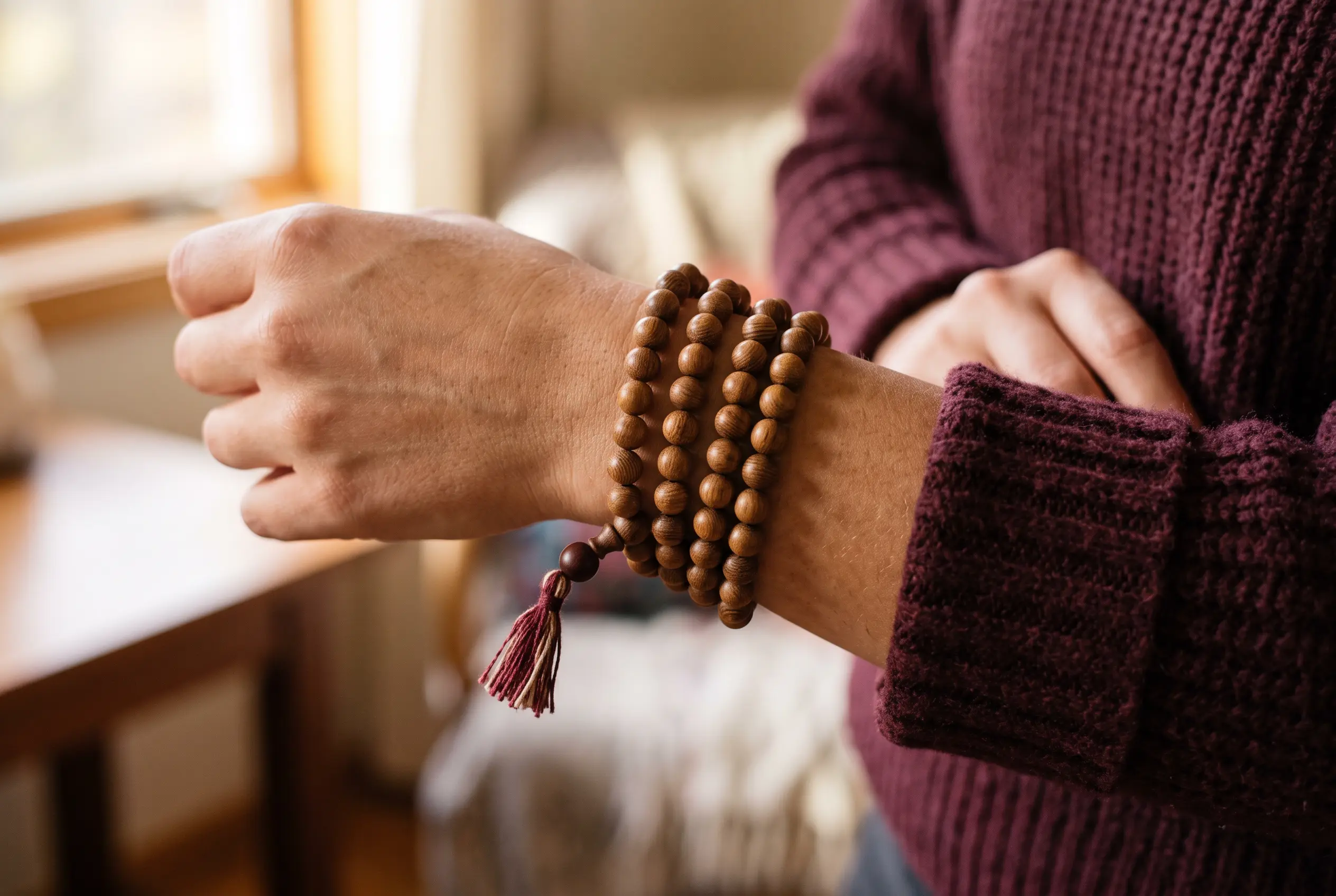 108-bead sandalwood mala bracelet wrapped four times around a wrist, a meditation gift under $30