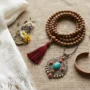 Guide de cadeaux de bijoux tibétains - présentation à plat Présentation à plat de bijoux tibétains authentiques, comprenant un mala de 108 perles, un bracelet en fil rouge et un pendentif turquoise, sur du lin.