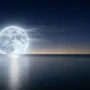 Luminous full moon reflected on calm water in a starry indigo sky, symbolizing the Cancer 2027 horoscope