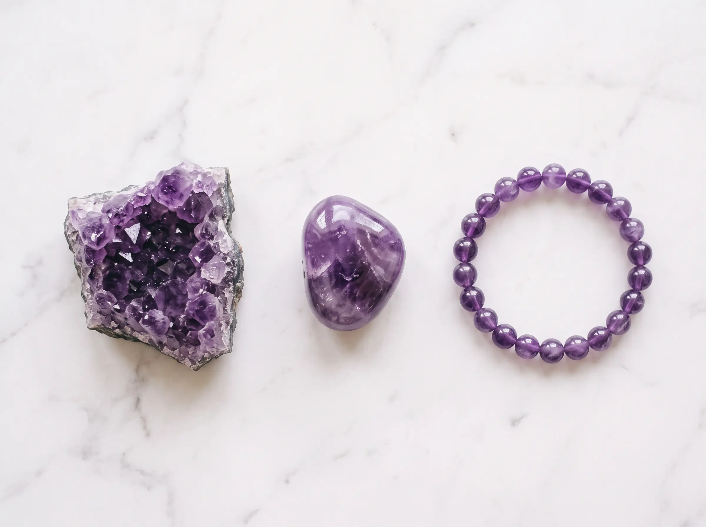 Comparison of raw amethyst geode, polished tumbled amethyst, and an amethyst bracelet side by side