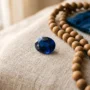 september-fødselsstein-safir-jomfruen-helt En dypblå safir på lin med tibetanske mala-perler, som representerer septembers fødselsstein for Jomfru-sesongen
